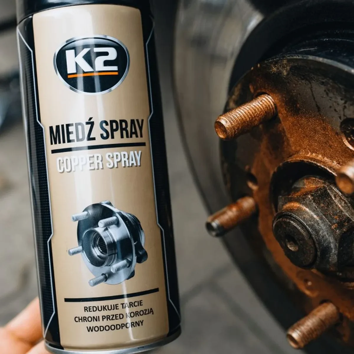K2 Copper Spray úðabrúsi við hjólnaf með koparlituðu varnarlagi.