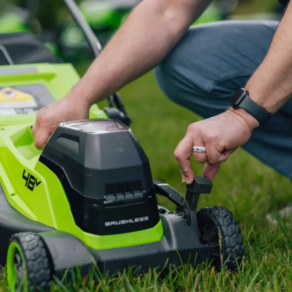 Sláttuhæð Greenworks 36 cm sláttuvélar stillt með stöng við hjólið.