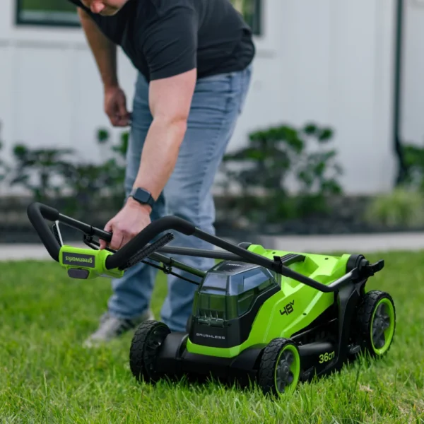 Handfang Greenworks 36 cm sláttuvélar fellt fram yfir vélina.