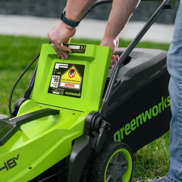 Gripið í burðarhandfang á Greenworks 36 cm sláttuvél við grassafnarann.