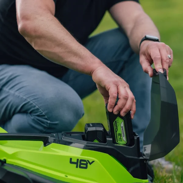 Rafhlöðuhólf Greenworks 36 cm sláttuvélar opið og rafhlaða sett í það.