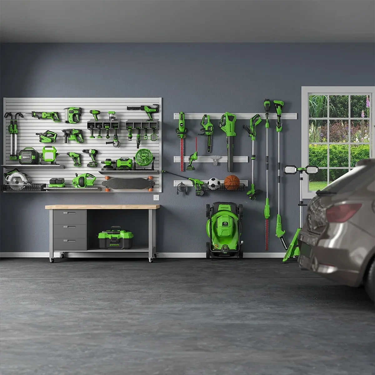 Greenworks verkfæri og garðtæki á vegg í bílskúr